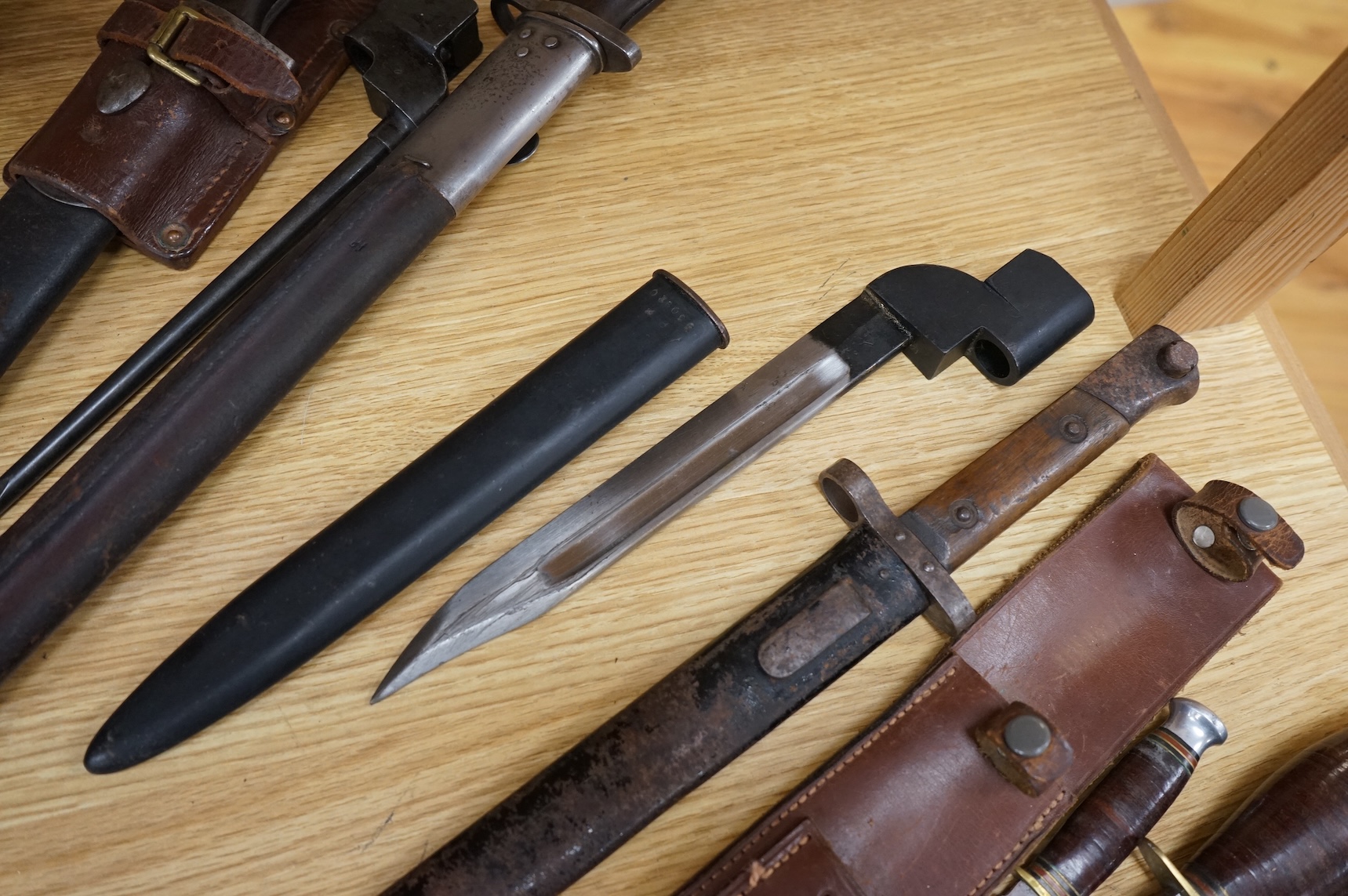 A 1907 bayonet by Wilkinson in its steel mounted leather scabbard, another similar with leather frog, two small British bayonets, a Continental bayonet, and two assorted hunting knives (7)